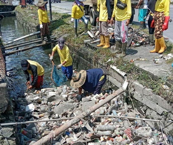 Pasukan kuning Dinas PUPR Pekanbaru membersihkan drainase yang dipenuhi sampah di simpang Tabek Gadang. Foto: Istimewa. 
